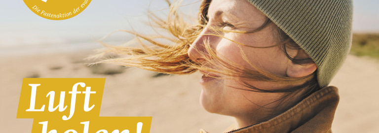 Frau von der Seite am Strand mit Haaren im Wind