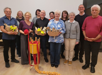 Gruppenbild mit elf Personen, davon drei mit Geschenkkörben in der Hand