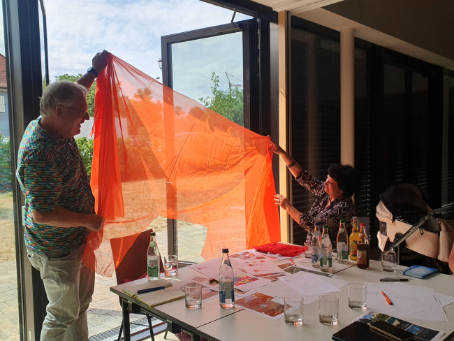Oranges Tuch wird gegen Licht gehalten