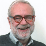 Mann mit grauem Bath und rot-brauner Brille