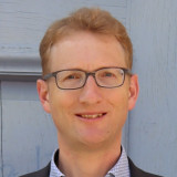 Mann mit Brille vor Kirchentür