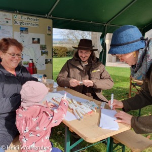 Menschen malen auf Bierbank unter Pavillon